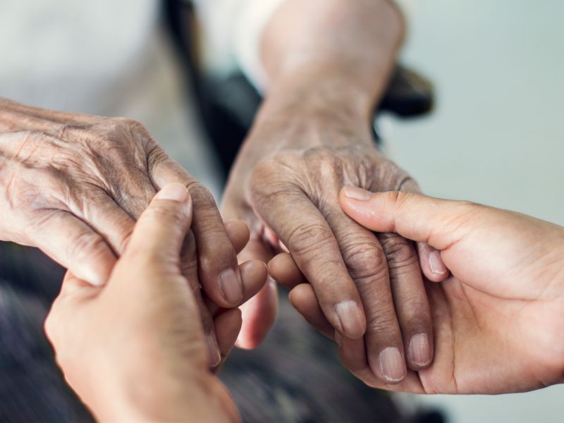 close up hands helping hands of older person