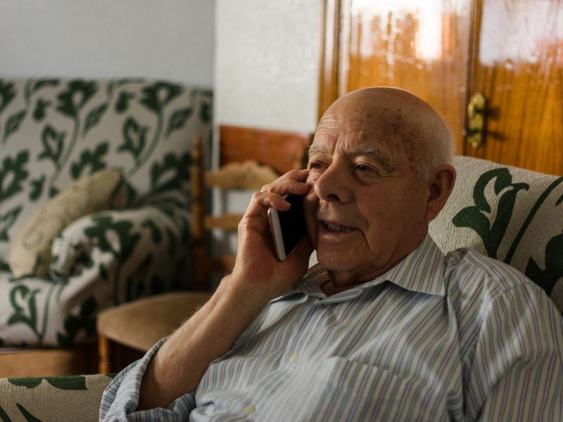 older man talking on phone